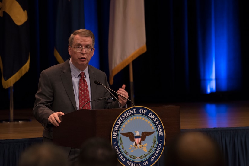 A man speaks at a lectern.