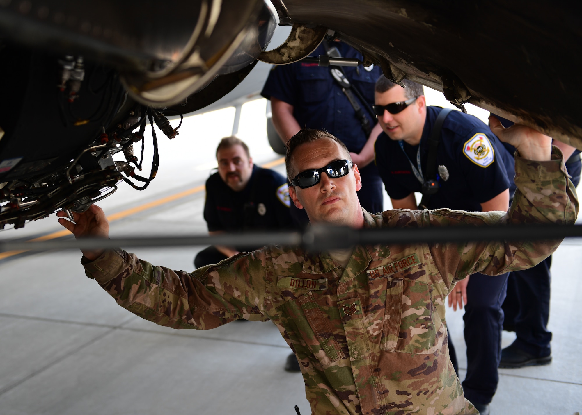 Tech. Sgt. Matthew Dillon, a crew chief with the 911th Aircraft Maintenance Squadron, opens a C-17 Globemaster III underside hatch for the Allegheny County Airport Authority Fire Rescue team at the Pittsburgh International Airport Air Reserve Station, Pennsylvania, May 9, 2019. Dillon showed the firefighters all of the places that may be flash points for fires as well as where valves and systems need to be turned off to prevent further damage to the aircraft during a fire. (U.S. Air Force Photo by Senior Airman Grace Thomson)