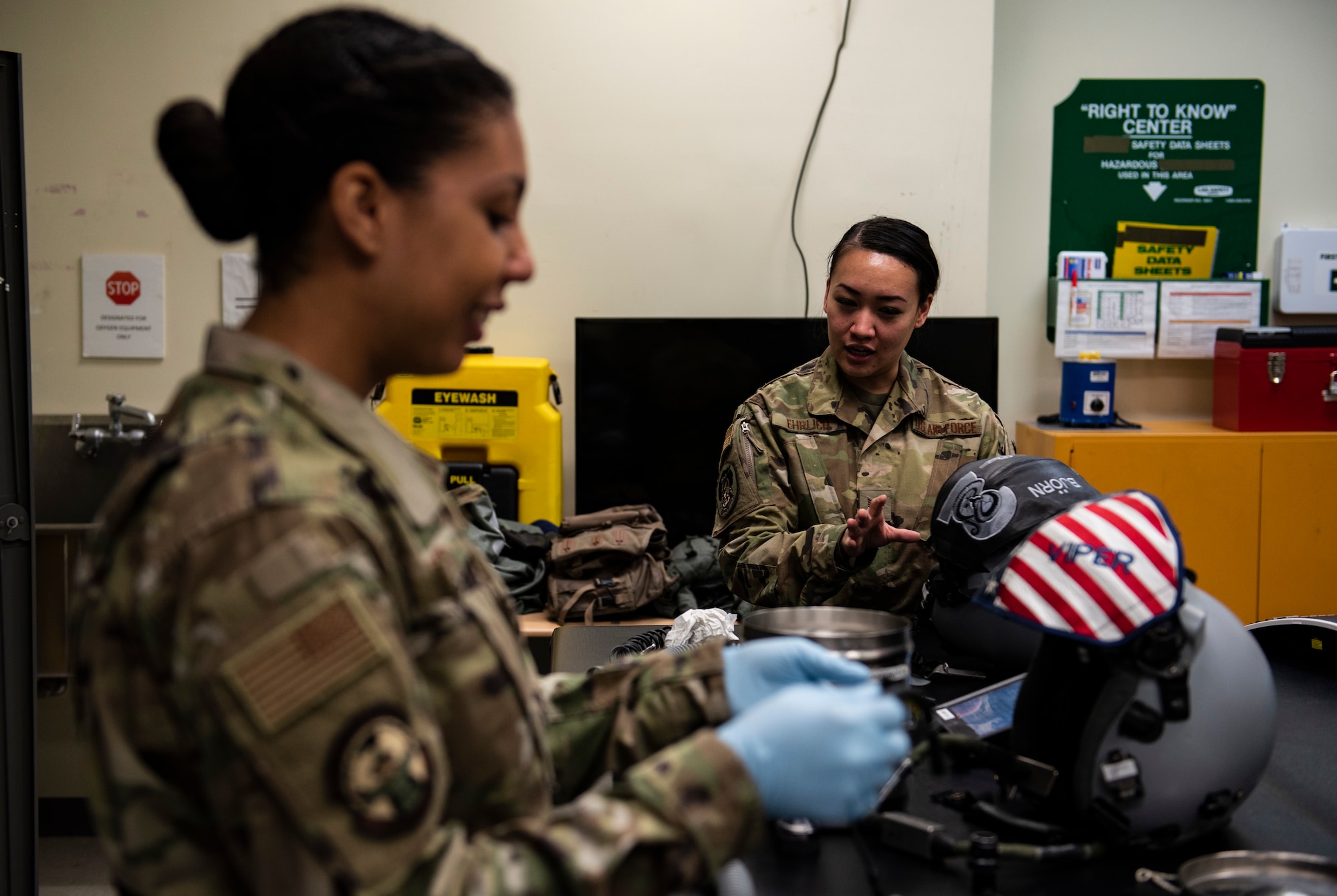 U.S. Air Force Staff Sgt. Vanessa Roper (left), 8th Operational Support Squadron aircrew flight equipment journeyman at the 35th Fighter Squadron “Pantons,” listens to Staff Sgt. Abegail Ehrlich, 8 OSS aircrew flight equipment journeyman at the 80th FS “Juvats,” while performing maintenance on a pilot’s helmet at Kunsan Air Base, Republic of Korea, April 29, 2019. While the AFE flight falls under the 8 OSS, the members work separately for the 80th and 35th FS in separate locations and don’t frequently work side by side. (U.S. Air Force photo by Senior Airman Stefan Alvarez)