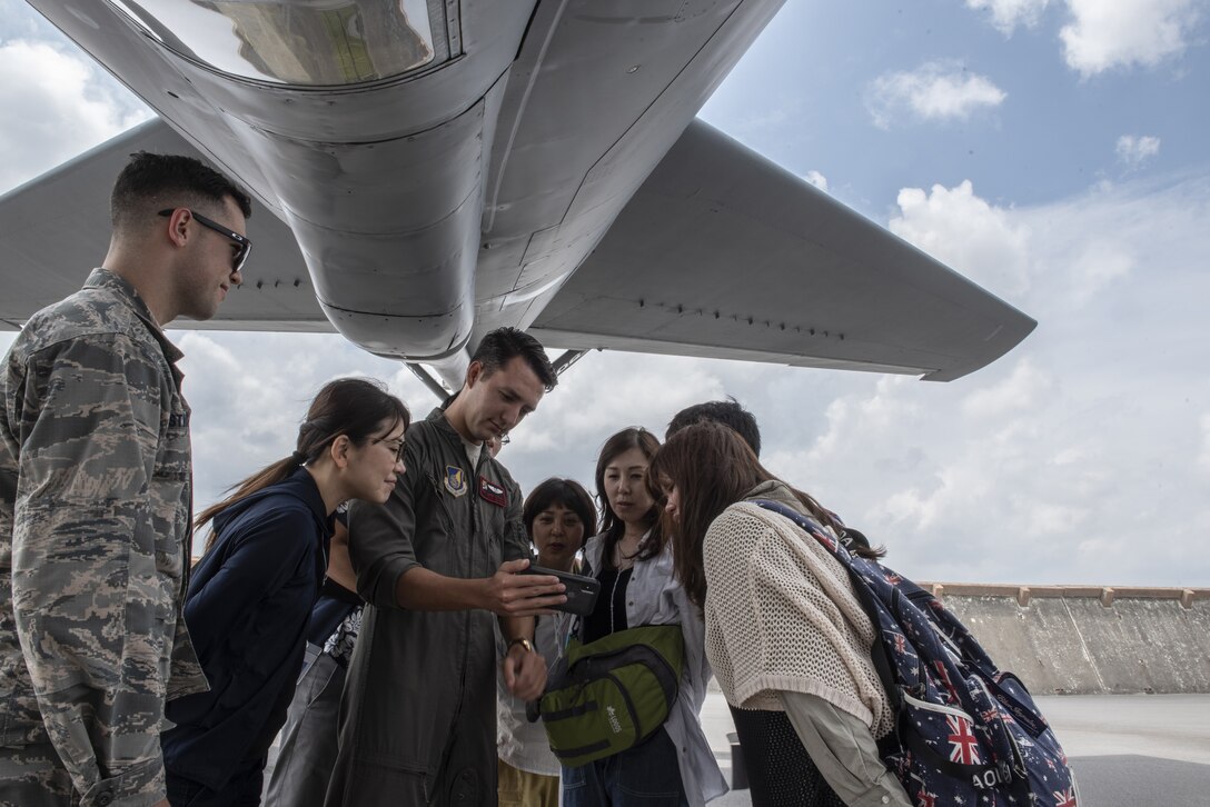 Senior Airman Luke Story, 909th Air Refueling Squadron boom operator, shows tour participants video of aerial refueling during a base tour of Kadena Air Base, Japan, May 8, 2019. The participants received a base mission brief and F-15 Eagle static display at Naha Air Base before traveling to Kadena for an 18th Wing mission brief and KC-135 Stratotanker static display. (U.S. Air Force photo by Tech. Sgt. Matthew B. Fredericks)