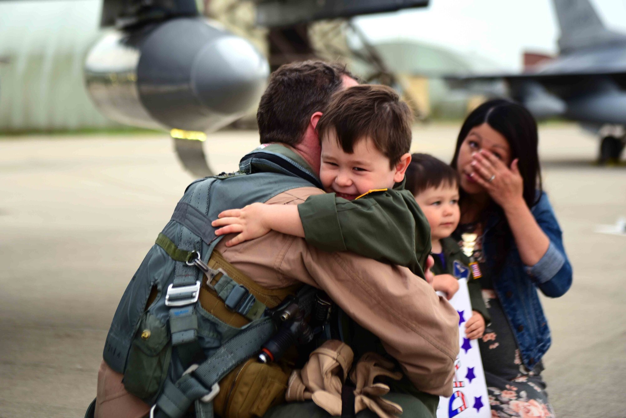 A 510th Fighter Squadron Airman returns home from a deployment and hugs his son at Aviano Air Base, Italy, April 30, 2019. Airmen returning home from deployment must start the re-integration process. (U.S. Air Force photo by Senior Airman Kevin Sommer Giron)