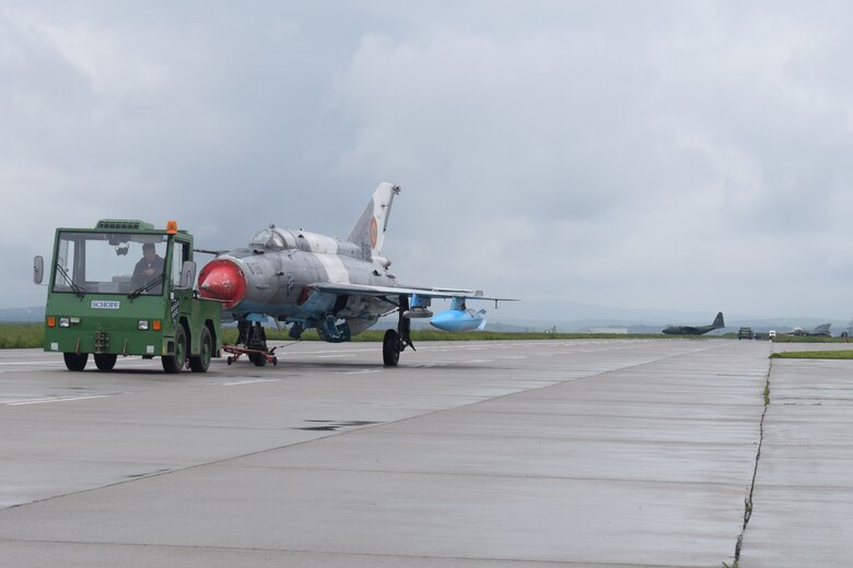 A Romanian MiG-21 LanceR is re-positioned near F-16C Fighting Falcon aircraft assigned to the 301st Fighter Wing, Naval Air Station Joint Base Fort Worth, Texas, deployed in support of Theater Security Package 19.1 as the 457th Expeditionary Fighter Squadron, Campia Turzii, Romania, May 10, 2019. Funded through the European Deterrence Initiative, TSP 19.1 provides a more robust U.S. military rotational presence in the European theater, capable of deterring, and if required, responding to regional threats. While in theater, these personnel and aircraft will participate in multiple readiness exercises alongside NATO allies and partners to strengthen interoperability and to demonstrate U.S. commitment to the stability and security of Europe (U.S. Air Force photo by 1st Lt. Andrew Layton).