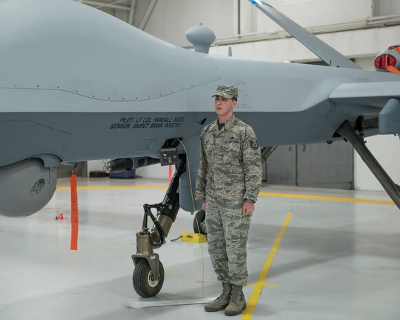 Staff Sgt. Mele ceremoniously unveils the name of the 491st Attack Squadron commander and their Dedicated Crew Chief on the side of an MQ-9 Reaper, during a squadron activation and assumption of command ceremony, May 8, 2019, on Hancock Field Air National Guard Base, N.Y. Lt. Col. Randall Noel, the 491st ATKS commander, formerly led the 6th and 16th Attack Squadrons on Holloman Air Force Base, N.M., as the Director of Operations. (U.S. Air Force photo by Airman 1st Class Kindra Stewart)