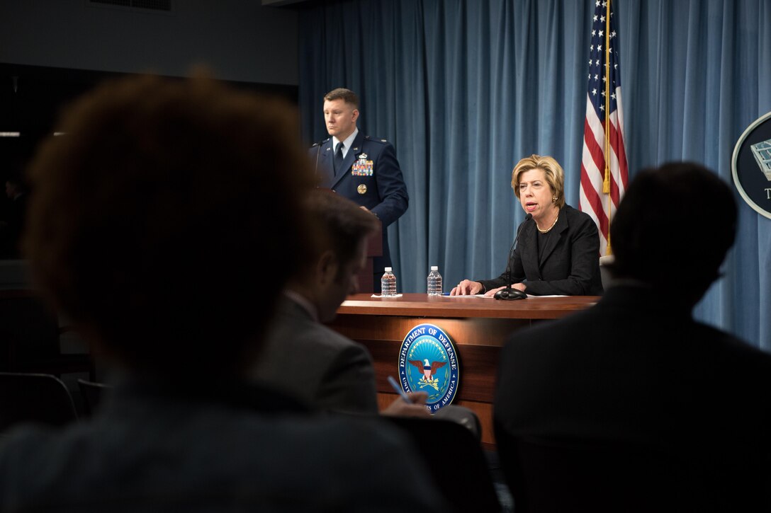 A woman briefs reporters at the Pentagon.