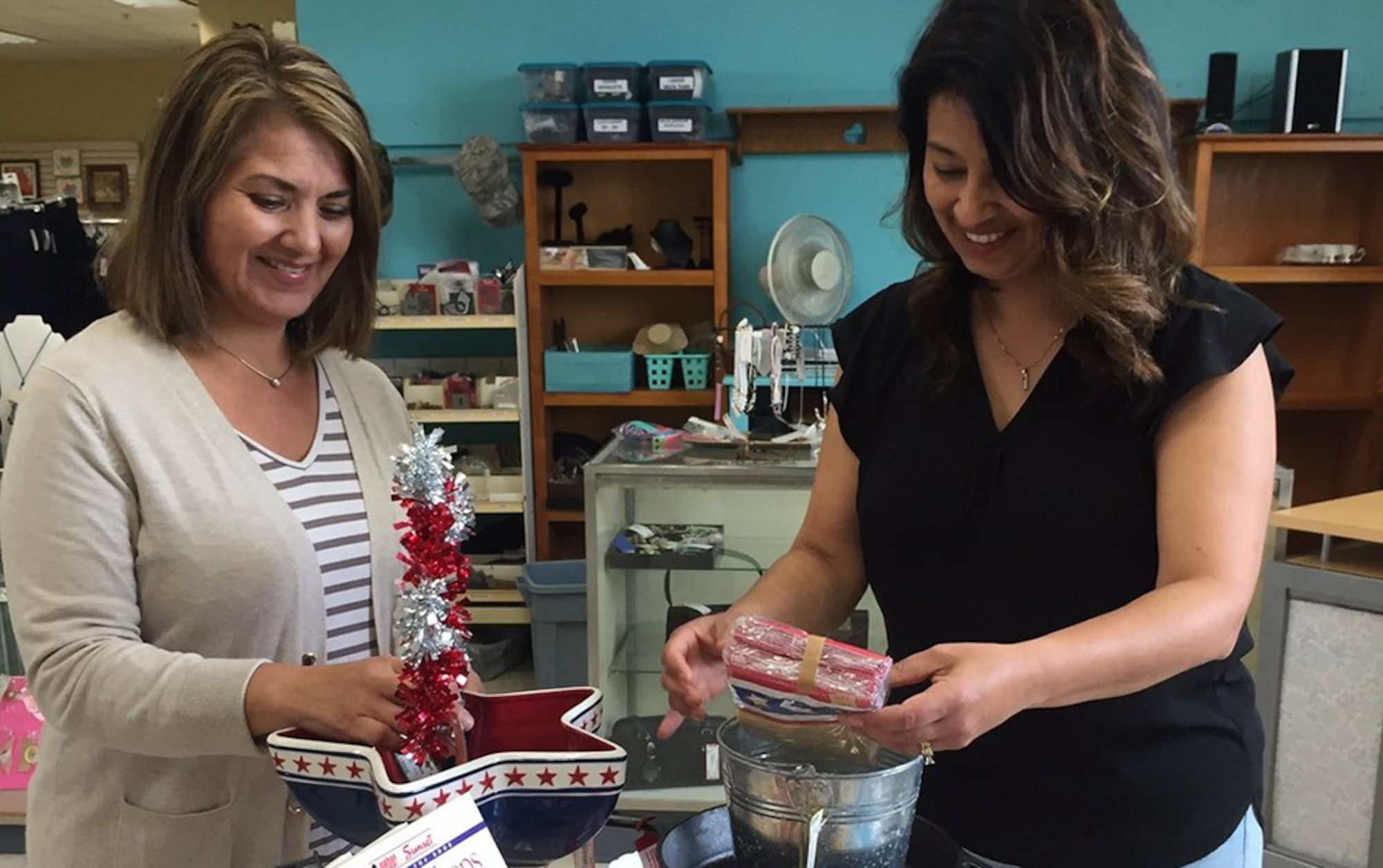 Diana André (left) assists Monica Lewis May 1 with arranging items for sale at the Thrift Shop, run by the Officers’ Spouses’ Club at Wright-Patterson Air Force Base. Anyone with a Department of Defense card can donate or consign items. Monies raised benefit Airmen, the base community and the Miami Valley. (Skywrighter photo/Amy Rollins)