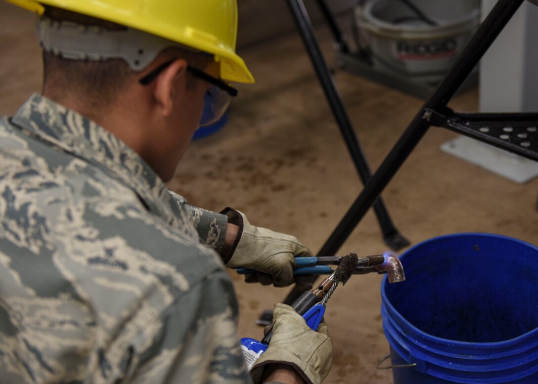 Airman Basic Ruben Segura, 366th Training Squadron water and fuels systems maintenance apprentice course student, prepares a piece of copper for soldering at Sheppard Air Force Base, Texas, May 8, 2019. Soldering is a process in which two or more items are joined together by melting and putting a filler metal into the joint. This process allows for the creation of a water channel from a water source to its various destinations. (U.S. Air Force photo by Senior Airman Ilyana A. Escalona)
