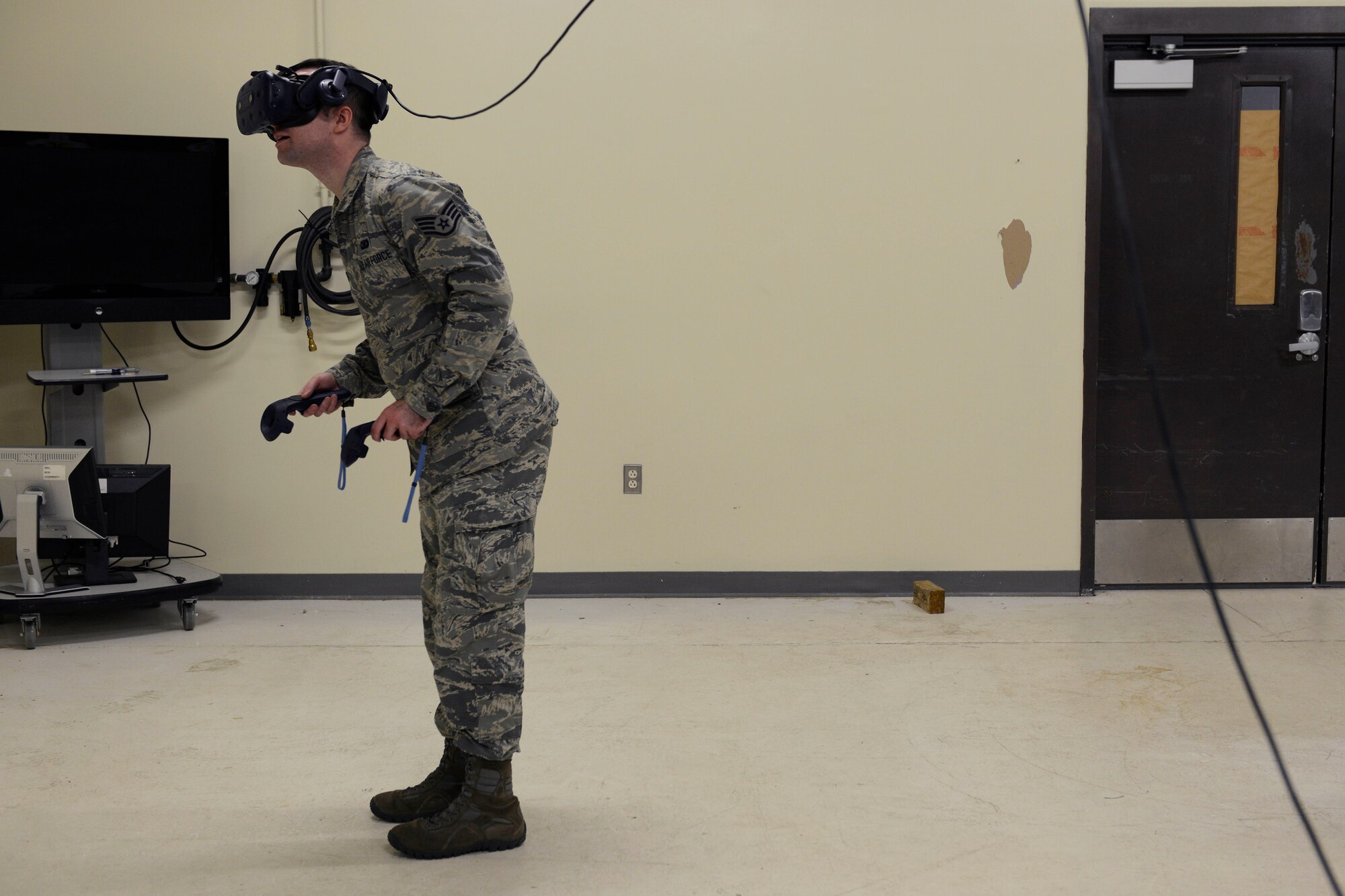 Staff Sgt. Steven Tucker, 103rd Airlift Wing broadcaster, trains on the Virtual Loadmaster Training System (VLTS) March 29, 2019 at Bradley Air National Guard Base, Conn. Tucker is holding two remotes that are used to simulate physical hand actions loadmaster must make during C-130 flights. (U.S. Air National Guard photo by Staff Sgt. Chad Warren)