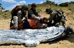 Air Force Reserve medical technicians and a Navy Reserve corpsman care for a simulated wounded patient during Operation Joint Medic May 5 at Joint Base San Antonio-Camp Bullis. The medics carried the patient by stretcher from a simulated firefight to a safer area to administer care until the patient could be evacuated by a Humvee and then onto a UH-60 Blackhawk from the Texas Army National Guard.