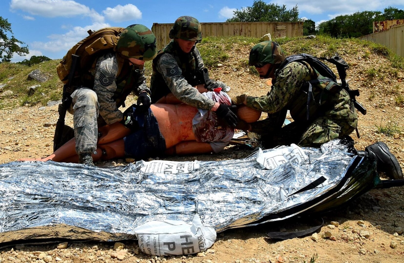 Air Force Reserve medical technicians and a Navy Reserve corpsman care for a simulated wounded patient during Operation Joint Medic May 5 at Joint Base San Antonio-Camp Bullis. The medics carried the patient by stretcher from a simulated firefight to a safer area to administer care until the patient could be evacuated by a Humvee and then onto a UH-60 Blackhawk from the Texas Army National Guard.