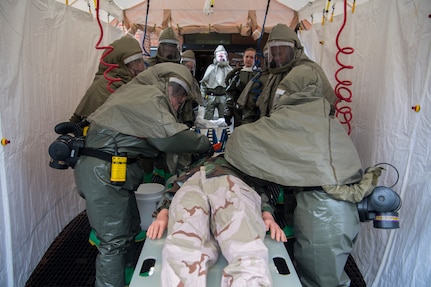 Airmen from the 628th Medical Group remove the clothes from a simulated casualty during an exercise May 9, 2019, at Joint Base Charleston, S.C.