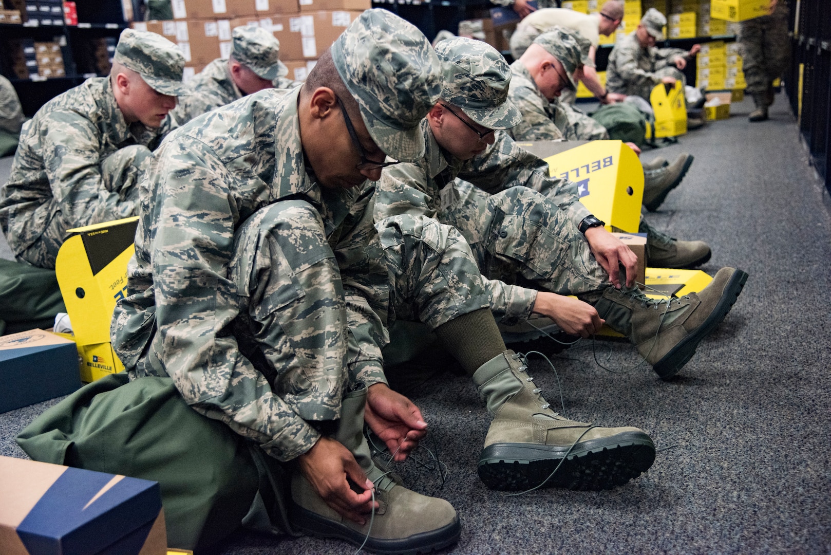 Trainees try on boots during initial clothing issue May 1, 2019, at Joint Base San Antonio-Lackland, Texas. Between 300 and 400 trainees receive their first sets of uniforms weekly from initial clothing issue. (U.S. Air Force photo by Senior Airman Stormy Archer)