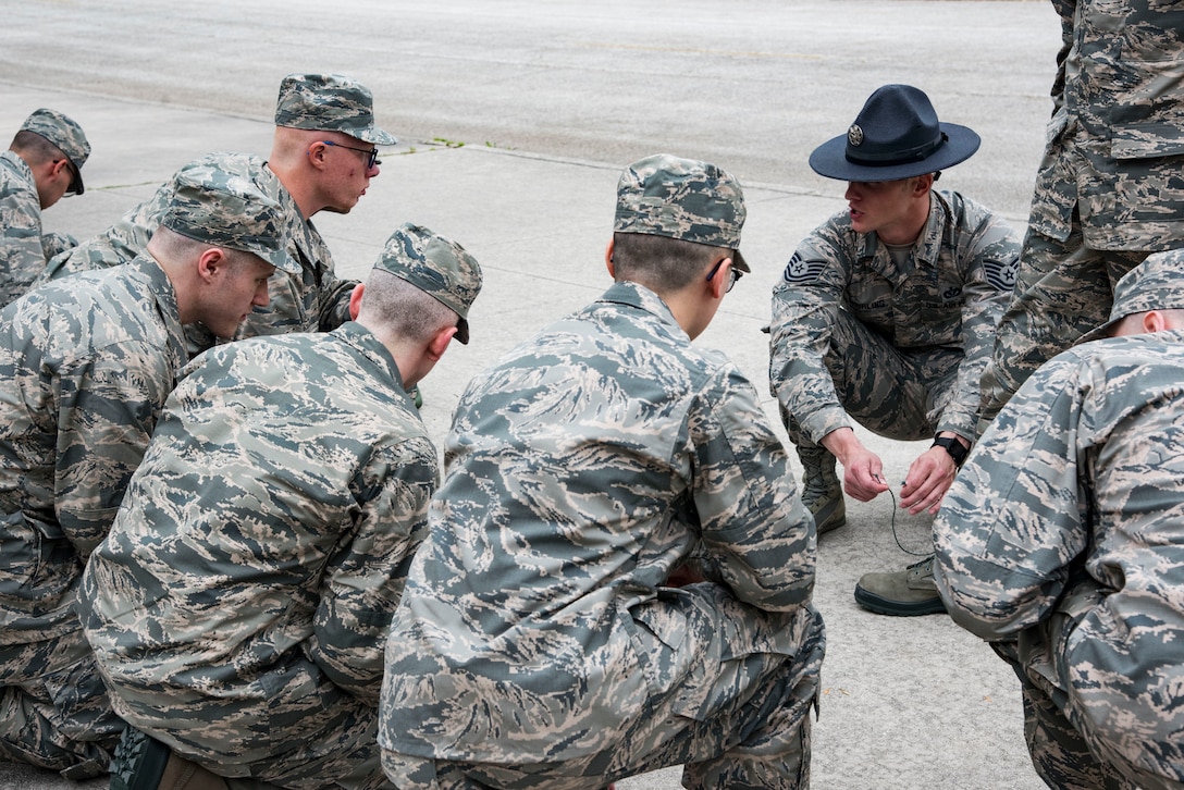 Tech. Sgt. Michael Shurling, 323rd Training Squadron military training instructor, shows his trainees how to properly tie boot laces May 1, 2019, at Joint Base San Antonio-Lackland, Texas. The 323rd TRS Provides world-class military leadership and training necessary to transform recruits into highly motivated Airmen possessing the foundational warrior attitudes, knowledge, skills and abilities to sustain the world's greatest Air Force. (U.S. Air Force photo by Senior Airman Stormy Archer)