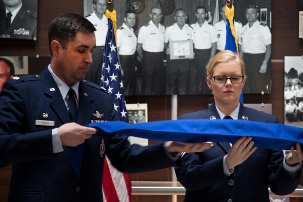 Lt. Col. Bill Havens, 42nd Combat Training Squadron commander, and Master Sgt. Kathryn Tichawa case the furled Reserve National Security Space Institute guidon during a redesignation ceremony May 5, 2019.