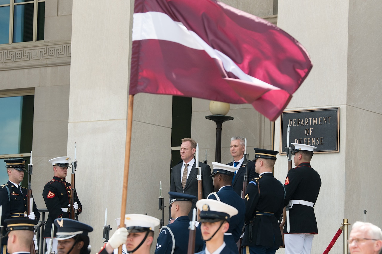 Two leaders stand at the main entrance of the Pentagon.