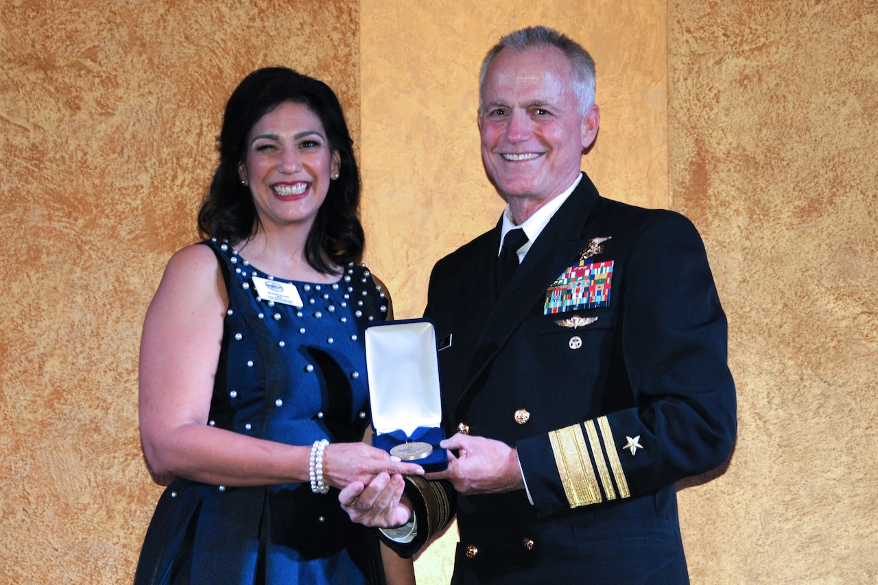 Two people pose for an awards photo.