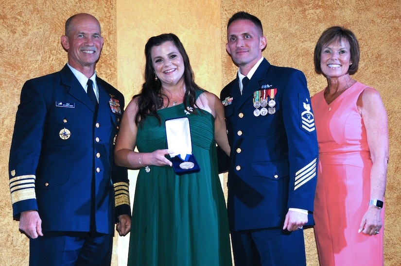 Four people stand in line for a posed awards photo.