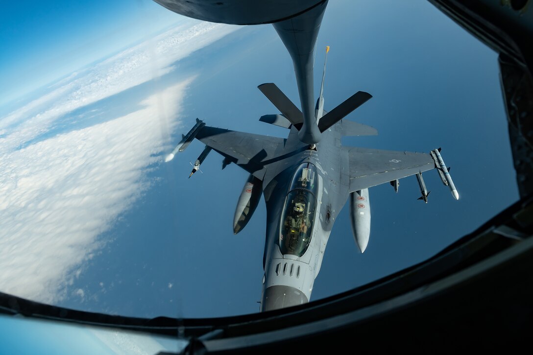 An aircraft receives fuel from another aircraft while flying.