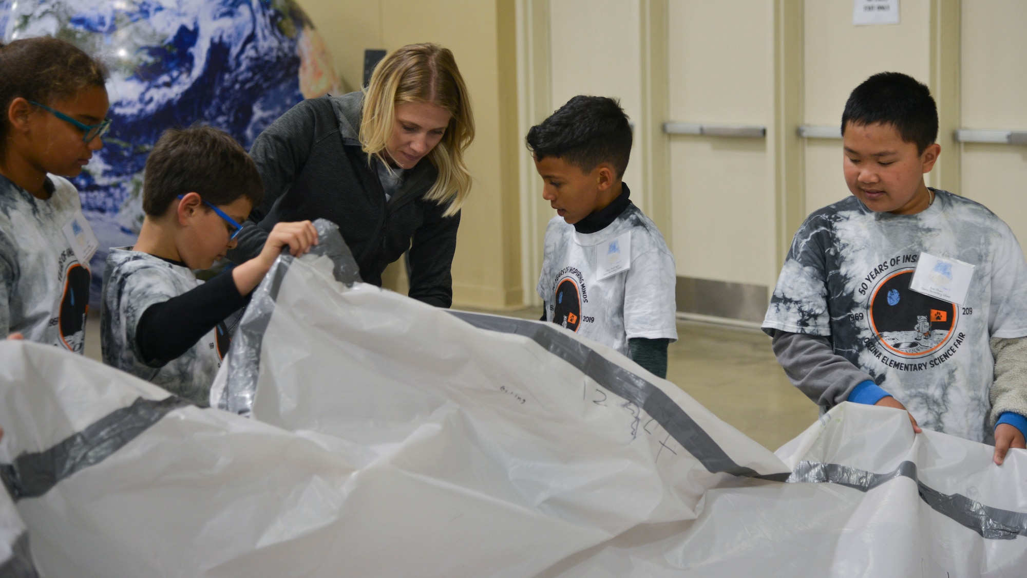 Tamara Torres and her students from Osuna Elementary inflate their habitat during the 2019 Mission to Mars at the Albuquerque Convention Center May 10. The Air Force Research Laboratory New Mexico’s STEM Outreach branch put on the mission, with more than 1,300 fifth-grade students from schools across the Albuquerque area and New Mexico taking part in the massive science and engineering experiment. (U.S. Air Force photo by Jim Fisher)
