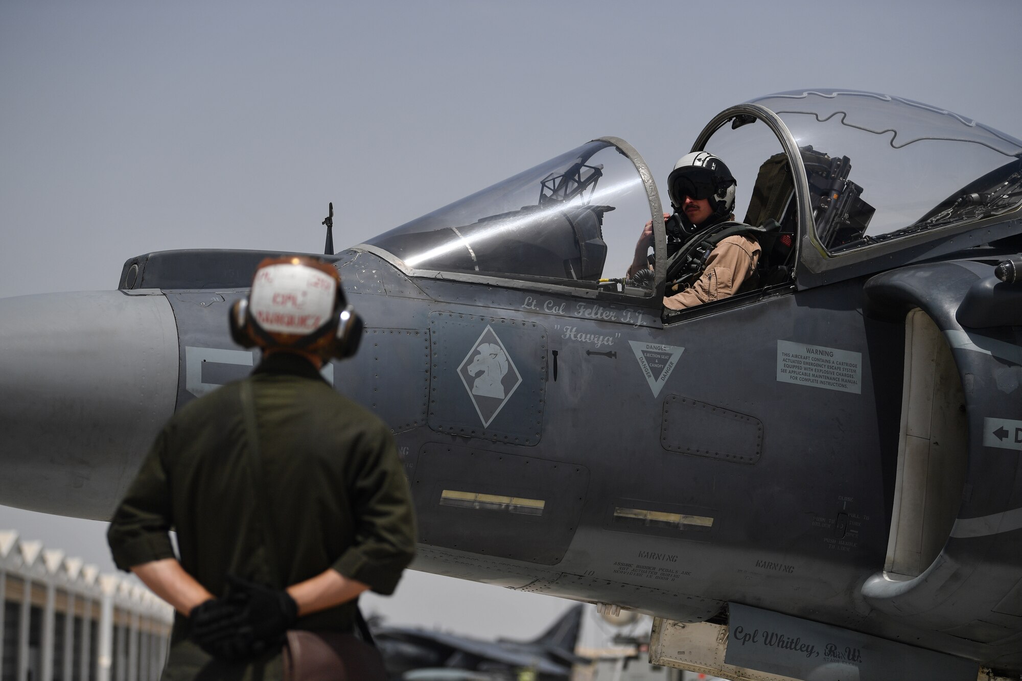 Two U.S. Marines conduct pre-flight checks on an AV-8B Harrier II during Desert Flag 19-2 in Southwest Asia, April 28, 2019. Desert Flag is designed to exercise combined Air Forces in military operations to enhance competence and strengthen military-to-military relationships and regional security.