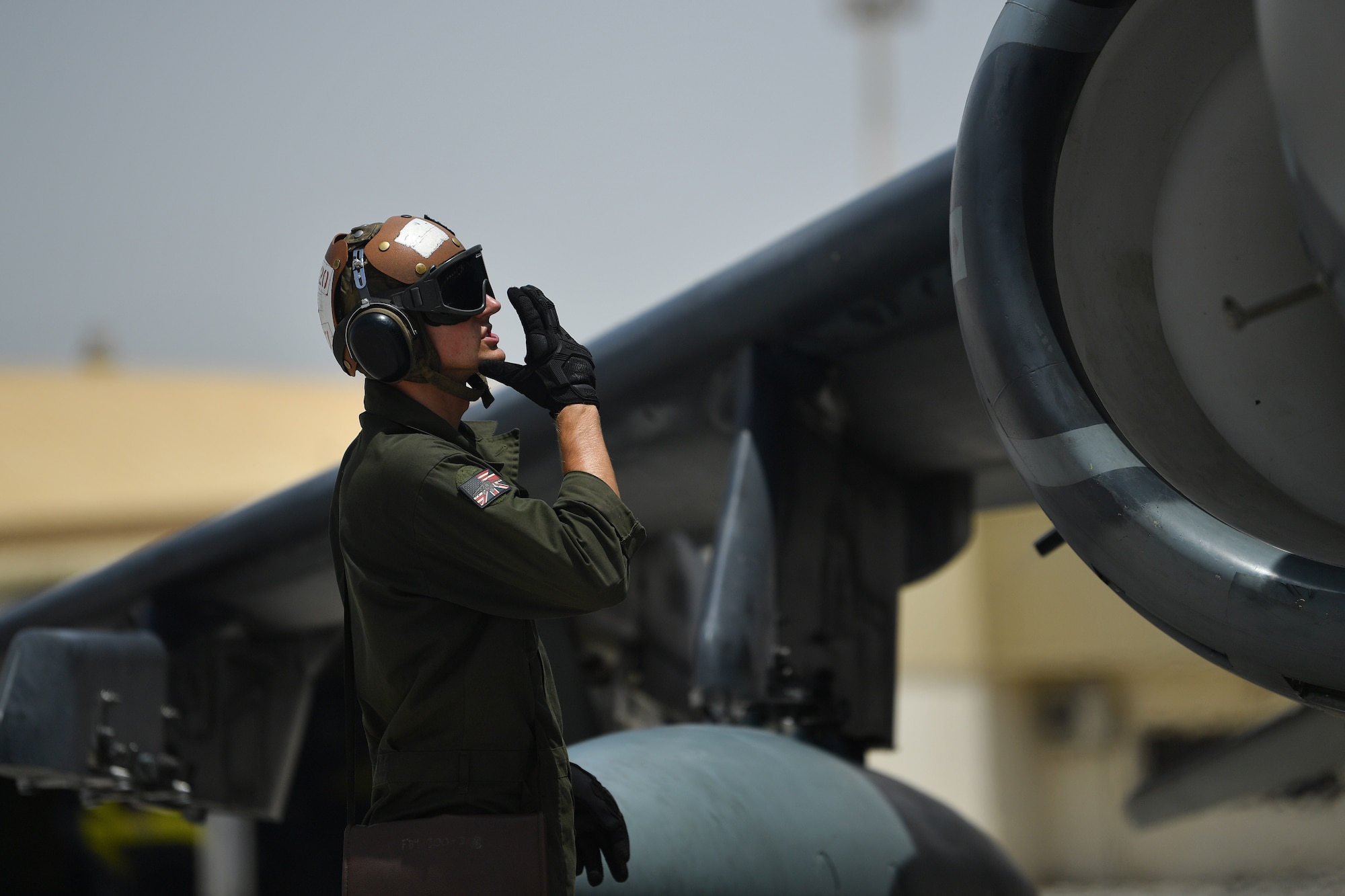 A U.S. Marine communicates with the pilot of an AV-8B Harrier II before taking off during Desert Flag 19-2 in Southwest Asia, April 28, 2019. Desert Flag is designed to exercise combined Air Forces in military operations to enhance competence and strengthen military-to-military relationships and regional security.