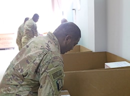 Sgt. Curtis Roach, 184th Sustainment Command, gathers mail from the post office at Camp Arifjan, Kuwait, April 29, 201