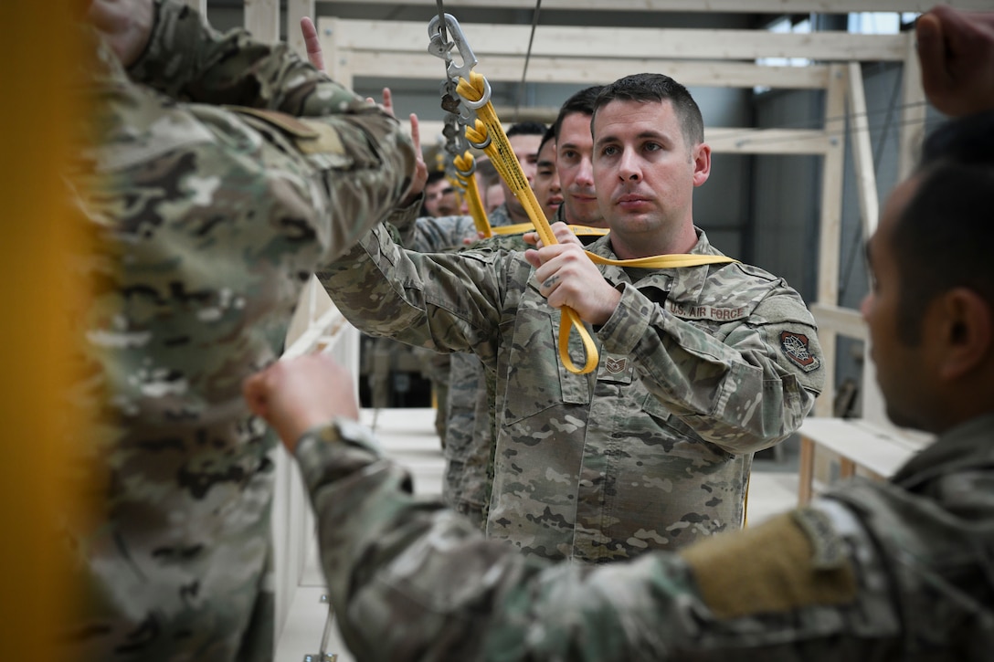 U.S. Air Force TSgt. Alex Rose, 721st Aerial Port Squadron special handling operator, gives the one-minute signal while securing a parachute static line during sustained airborne demonstration.