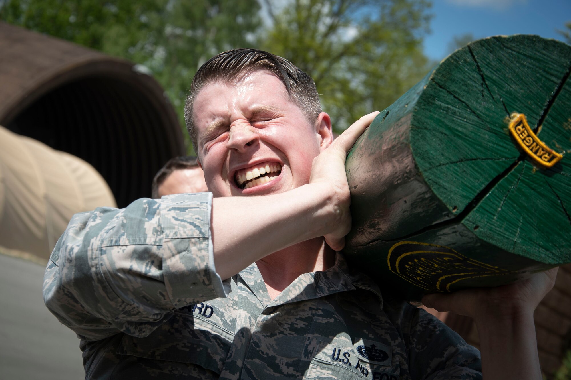 Technical Sgt.  Jason Allard, 48th Communication Squadron noncommissioned officer in charge of quality assurance, rests a log on his shoulder during a team building event.