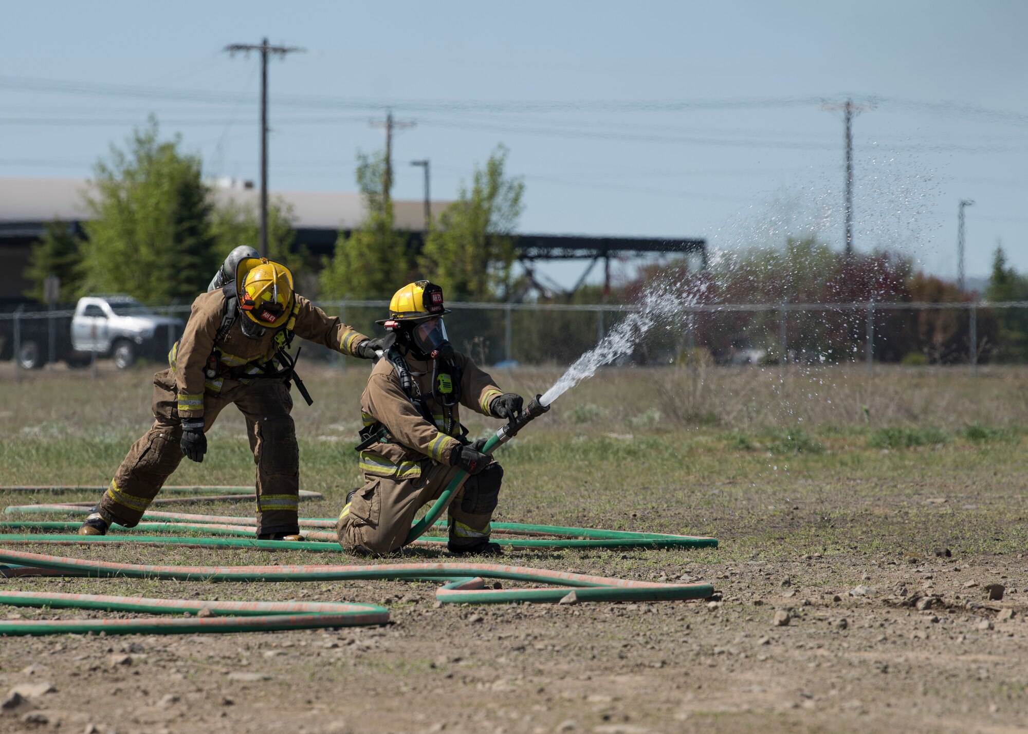 Firefighters from the Airway Heights Fire Department test hose pressure while preparing for a Major Accident Response Exercise drill near Fairchild Air Force Base, Washington, May 9, 2019.