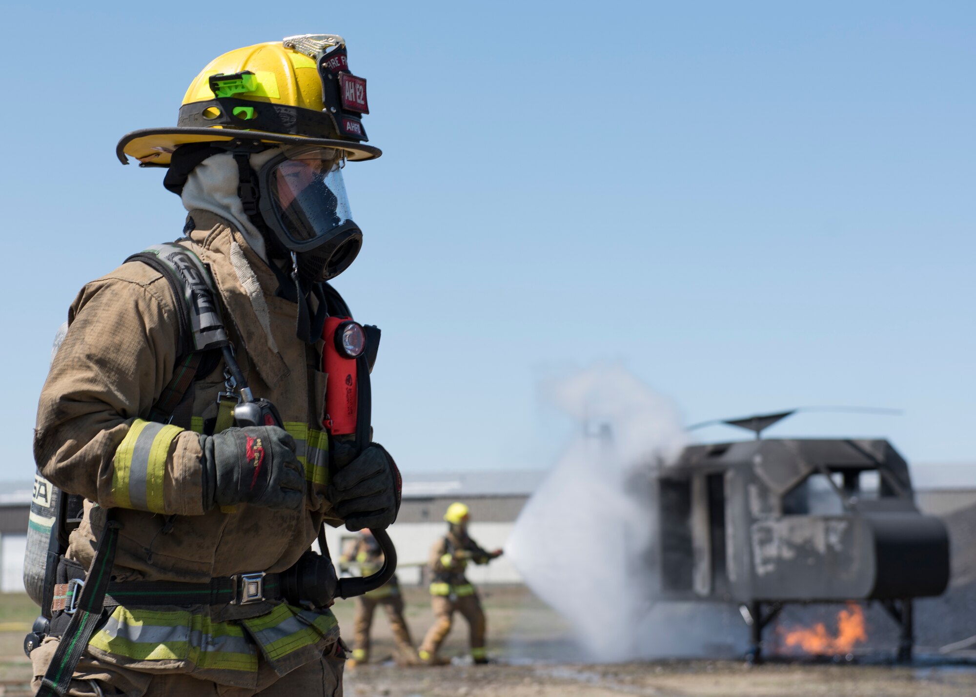 A firefighter from the Airway Heights Fire Department the scene around a helicopter crash trainer during a Major Accident Response Exercise drill near Fairchild Air Force Base, Washington, May 9, 2019.