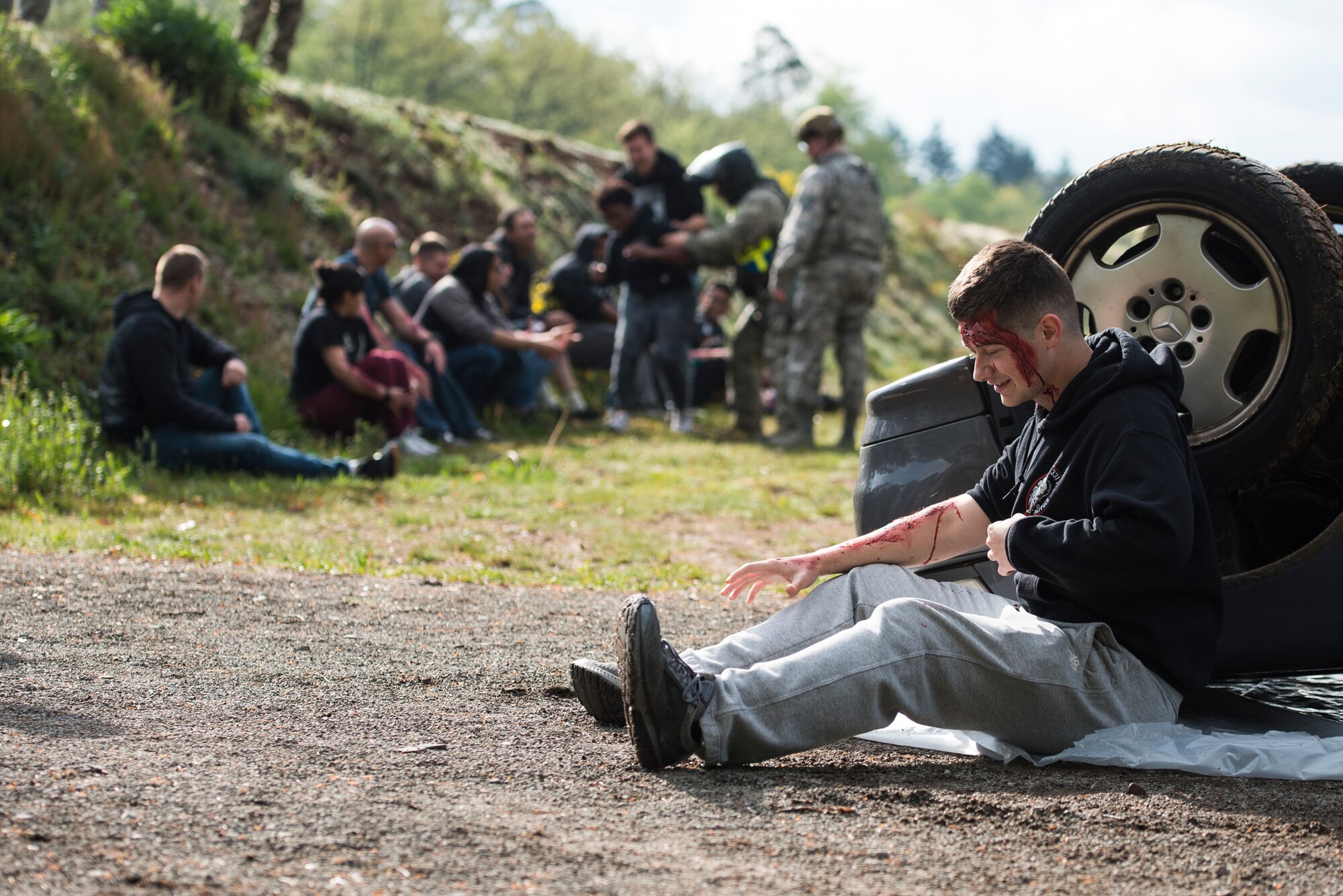 A simulated traffic accident victim sits up during Exercise Operation Varsity 19-02 on Ramstein Air Base, Germany, May 10, 2019. Team Ramstein was tested on its ability to respond to mass casualty incidents on base. (U.S. Air Force photo by Senior Airman Devin M. Rumbaugh)