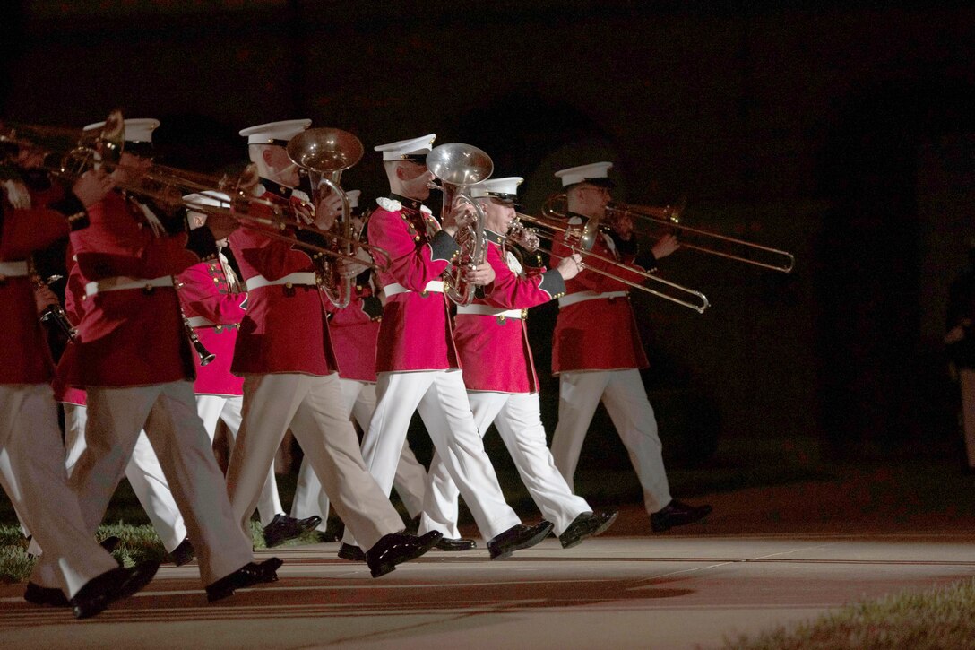 A group of people in uniform play instruments while walking in a parade.