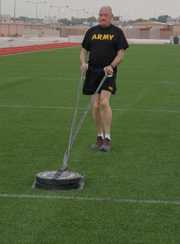 Command Sgt. Maj. Paul Horan, senior enlisted advisor, 1st Battalion, 114th Infantry Regiment, drags a 90-pound sled the required 50 meters during a familiarization training on the new Army Combat Fitness Test at Camp As Sayliyah, Qatar, May 4, 2019.