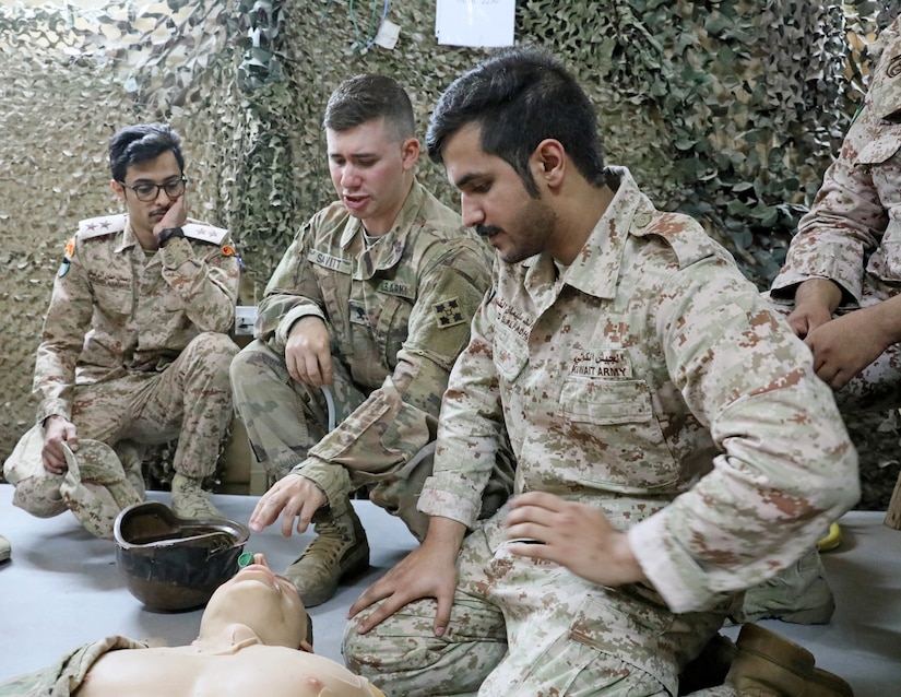 U.S. Army Spc. Thomas Savitt, center, a medic with 64th Brigade Support Battalion, 3rd Armored Brigade Combat Team, 4th Infantry Division, Task Force Spartan, demonstrates for Kuwaiti Land Forces Soldiers from the 11th Engineer Battalion how to place a nasopharyngeal airway on a casualty during partner training at Camp Buehring, Kuwait on April 3, 2019. The training was just one of many opportunities for partnering Kuwaiti and U.S. forces to learn best practices from each other.