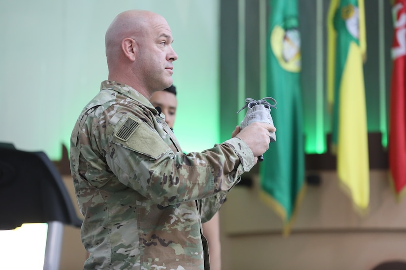 U.S. Army Capt. Anthony Williams, a physical therapist with the 3rd Armored Brigade Combat Team, 4th Infantry Division, Task Force Spartan, uses a shoe as a visual aid as he presents a lecture on proper running technique at the Kuwait National Guard Headquarters on Tuesday, April 30, 2019. During his lecture, Williams used a variety of visual tools to help communicate with the Kuwaiti audience despite language barriers.