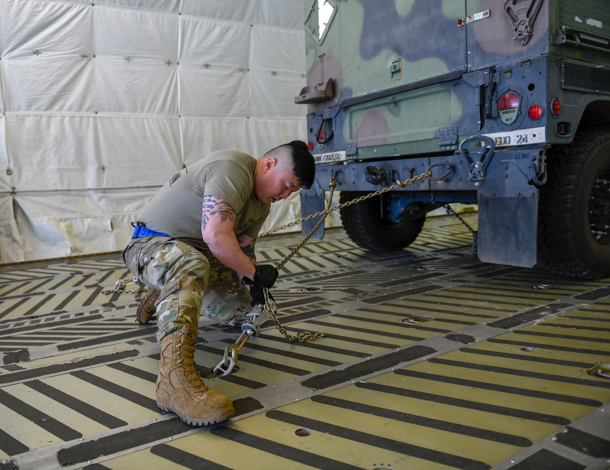 Master Sgt. Tae Choe (left), a ramp services supervisor, Master Sgt. Zach Dunkin (right), NCO in charge of load planning, and Tech. Sgt. Michael Nippers Jr. (right), all assigned to the 76th Aerial Port Squadron, tie down cargo for the pallet build-up event at the Port Dawg Challenge April 24, 2019.