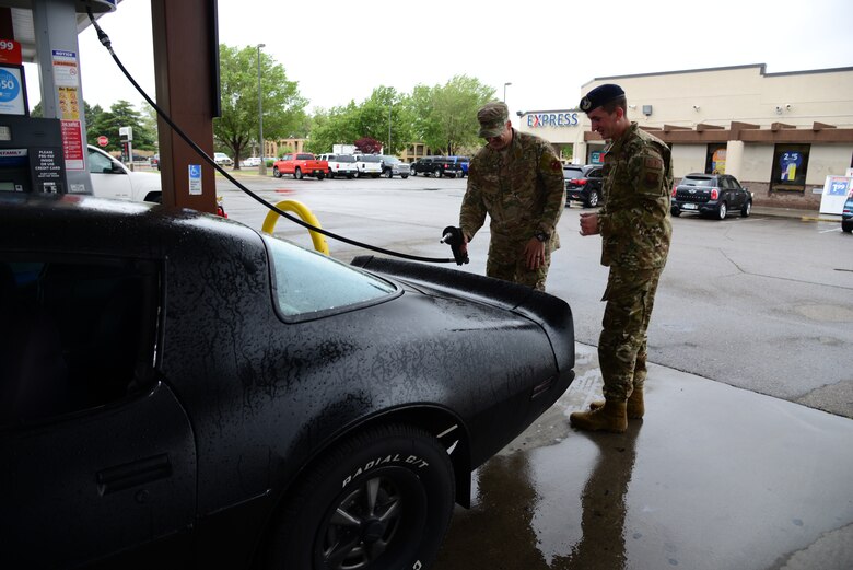 Airman First Class Steven Sanders, 377th Weapons Systems Security Squadron, talks with Senior Master Sergeant Daniel Burton, 58th Aircraft Maintenance Squadron first sergeant and Team Kirtland First Sergeants Council president during a random act of kindness event where the council provided 500 dollars worth of free gas to E-4 Airmen and below at Kirtland Air Force Base, N.M., May 10. Random acts of kindness is a campaign that strives to increase morale and thank Airmen for their service by distributing First Sergeants Council funds back to the base community. (U.S. Air Force photo by Jessie Perkins)