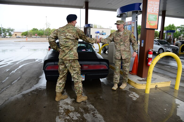 Airman First Class Steven Sanders, 377th Weapons Systems Security Squadron, shakes hands with Senior Master Sergeant Daniel Burton, 58th Aircraft Maintenance Squadron first sergeant and Team Kirtland First Sergeants Council president during a random act of kindness event where the council provided 500 dollars worth of free gas to E-4 Airmen and below at Kirtland Air Force Base, N.M., May 10. Random acts of kindness is a campaign that strives to increase morale and thank Airmen for their service by distributing First Sergeants Council funds back to the base community. (U.S. Air Force photo by Jessie Perkins)