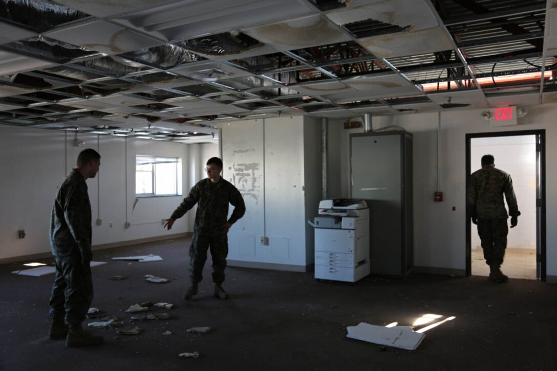Marines survey storm damage in a building