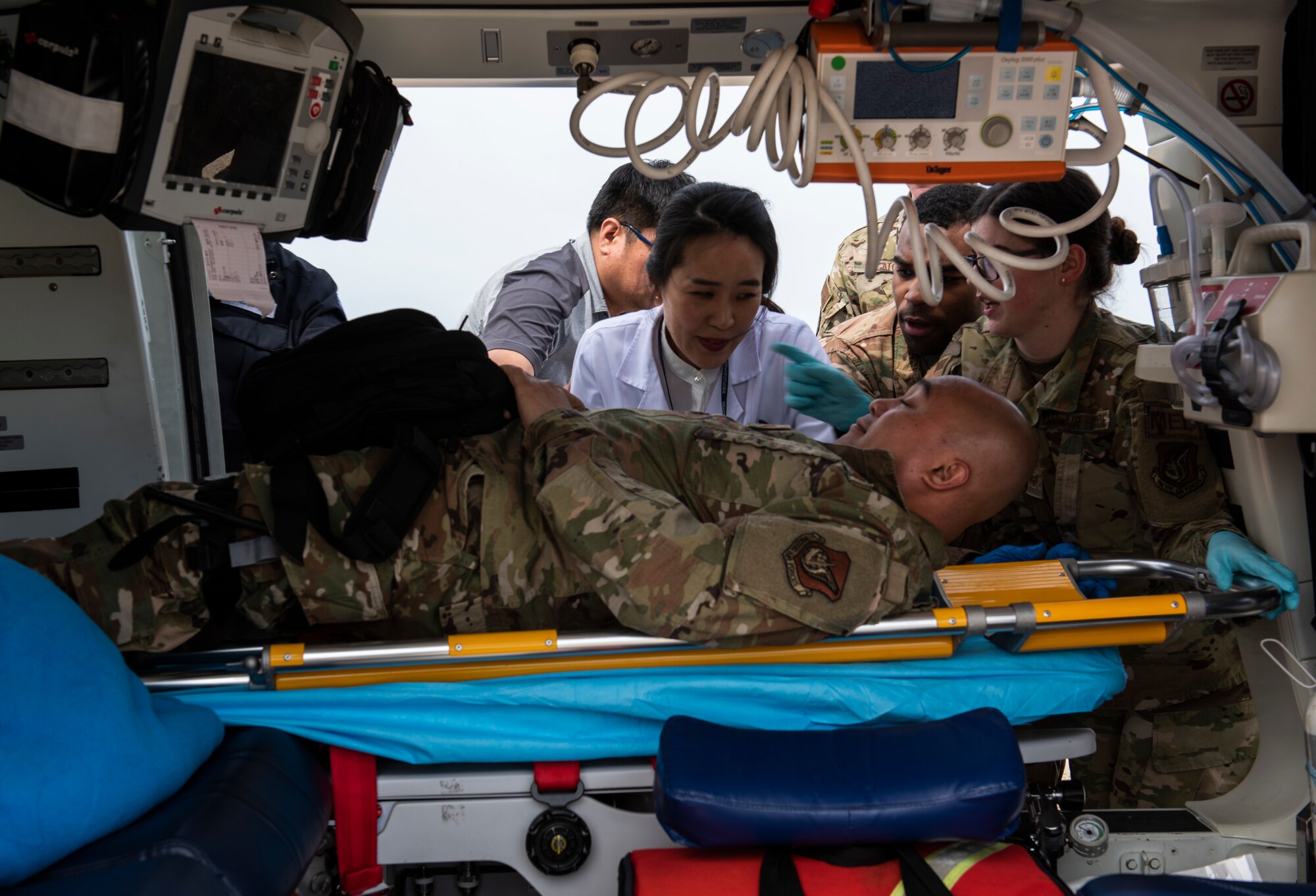Airmen from the 8th Medical Group and medical staff from Wonkwang University Medical Center load a simulated patient on a helicopter at Kunsan Air Base, Republic of Korea, May 8, 2019. 8th MDG worked closely with the staff at Wonkwang to test how the facility could accommodate an air lift emergency from Kunsan. (U.S. Air Force photo by Senior Airman Stefan Alvarez)