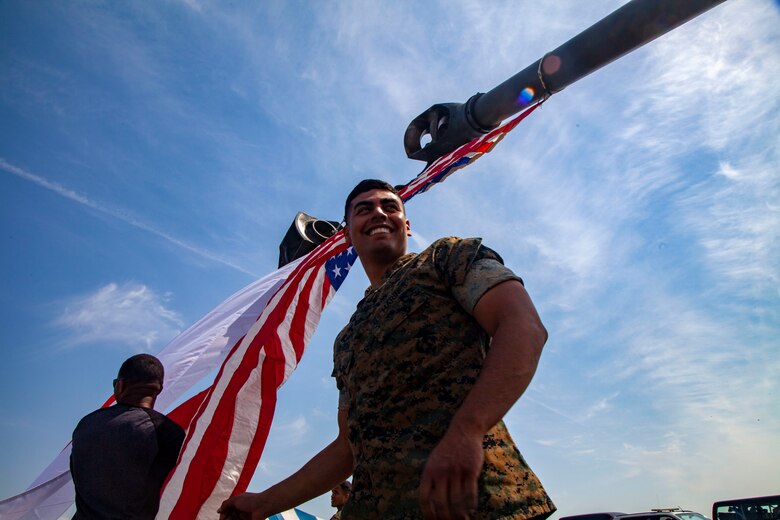 Lance Cpl. Alberto Salceda, an Orange County, California, native, and field artillery cannoneer with 3rd Battalion, 12th Marine Regiment, helps raise the American flag during the Friendship Festival May 11, 2019, on Combined Arms Training Center Camp Fuji, Shizuoka, Japan.