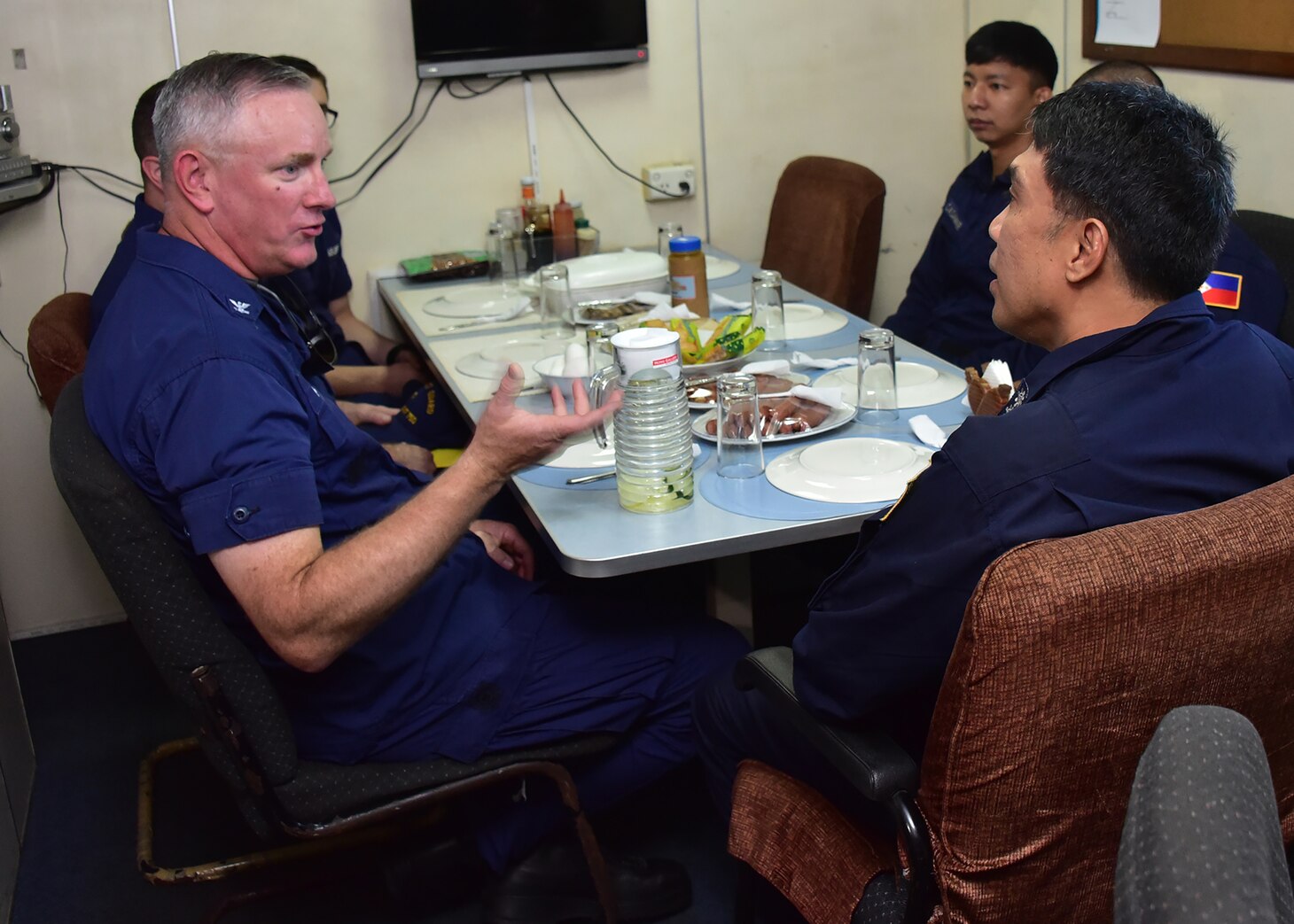 SOUTH CHINA SEA (May 14, 2019) - Captain John J. Driscoll, left, enjoys breakfast aboard the Philippine Coast Guard vessel Batangas along with Batangas commanding officer, right foreground, and other officers prior to a search and rescue exercise west of Manila May 14, 2019.  Bertholf is conducting a Western Pacific patrol under the tactical control of the U.S. Navy’s 7th Fleet.