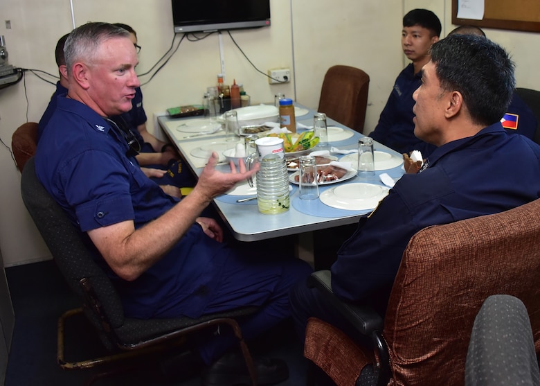 SOUTH CHINA SEA (May 14, 2019) - Captain John J. Driscoll, left, enjoys breakfast aboard the Philippine Coast Guard vessel Batangas along with Batangas commanding officer, right foreground, and other officers prior to a search and rescue exercise west of Manila May 14, 2019. Bertholf is conducting a Western Pacific patrol under the tactical control of the U.S. Navy’s 7th Fleet. (Photo by Chief Petty Officer John Masson)