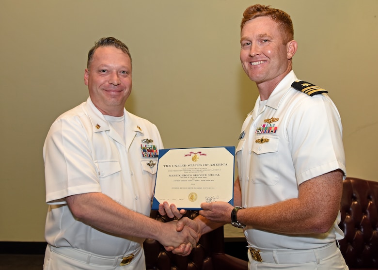 U.S. Navy Chief Petty Officer Joseph Reynolds, Senior Enlisted Leader for Center for Information Warfare Training detachment Goodfellow, presents Lt. Cmdr. J. Austin Maxwell, CIWT detachment Goodfellow officer in charge, the Navy and Marine Corps Commendation medal during the change of charge ceremony at the event center on Goodfellow Air Force Base, Texas, May 9, 2019. The Navy and Marine Corps Commendation medal was awarded to him for distinguishing himself by heroic or meritorious achievement or service. (U.S. Air Force photo by Airman 1st Class Ethan Sherwood/Released)