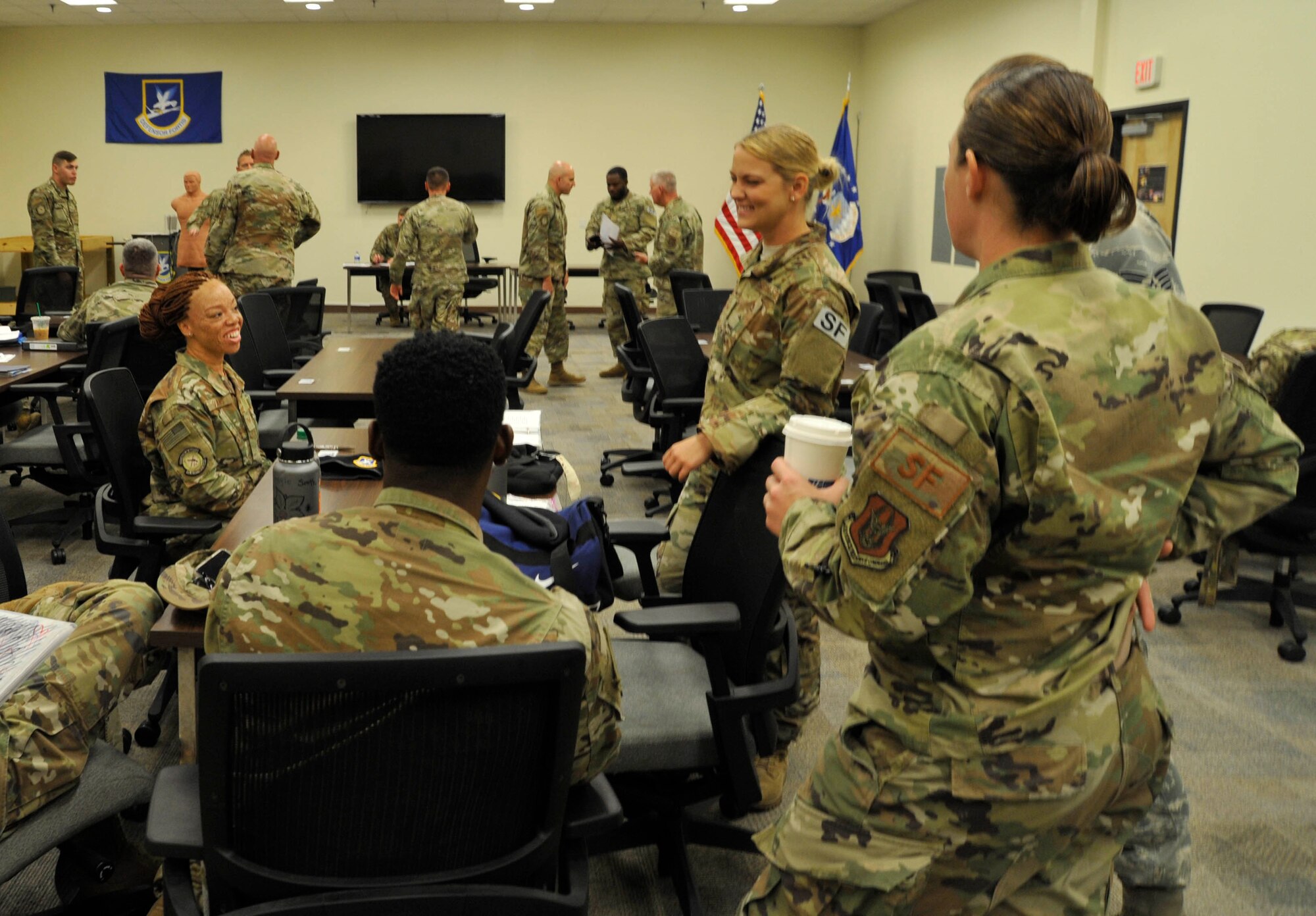 Senior Airman Tiffany Evans (left, seated) 403rd Security Forces Squadron member smiles while listening to other Airmen inside the 403rd Security Forces Squadron building, May 8, 2019, Keesler Air Force Base, Mississippi.  Over 30 members of the 403rd Security Forces Squadron returned from a 180-day deployment to the United Arab Emirates where they provided security to the Al Dhafra Air Base from October 2018 to May 2019. (U.S. Air Force photo by Tech. Sgt. Michael Farrar)