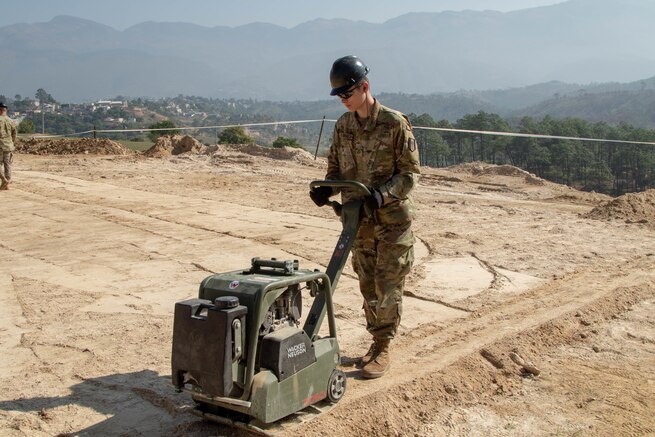 A U.S. Army Soldier compacts dirt with a tamper at the Aldea Eucalypto school construction site in Huehuetenango, Guatemala.