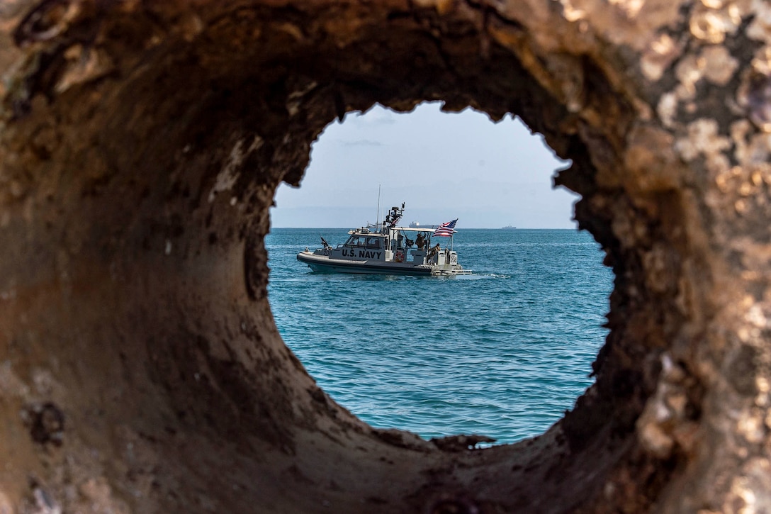 A look at a boat in water through a hole.