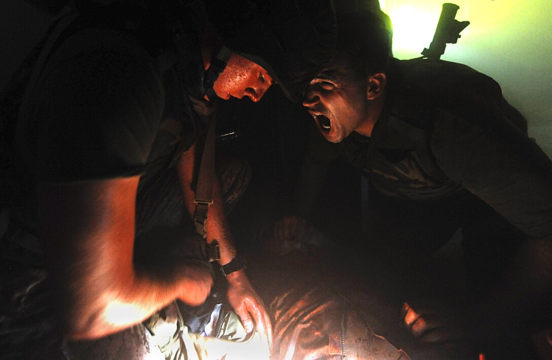 Hospital corpsman, right, gives instruction to Sailor during field training exercise portion of Tactical Combat Casualty Care training, Schofield Barracks, Hawaii, May 31, 2013 (U.S. Navy/Sean Furey)