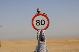 A Kuwait work crew reassembles a speed limit sign found detached from its pole during a traffic safety sign setup initiative conducted along routes in the vicinity of Camp Buehring, Kuwait, May 11, 2019.