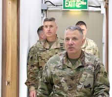 Col. Douglas Ottenberg, director of 398th Financial Management Support Center leads Maj. Gen. Bradley Dreyer,  deputy chief of staff, G8, during a visit at Camp Arifjan, Kuwait, Mar. 16, 2019.