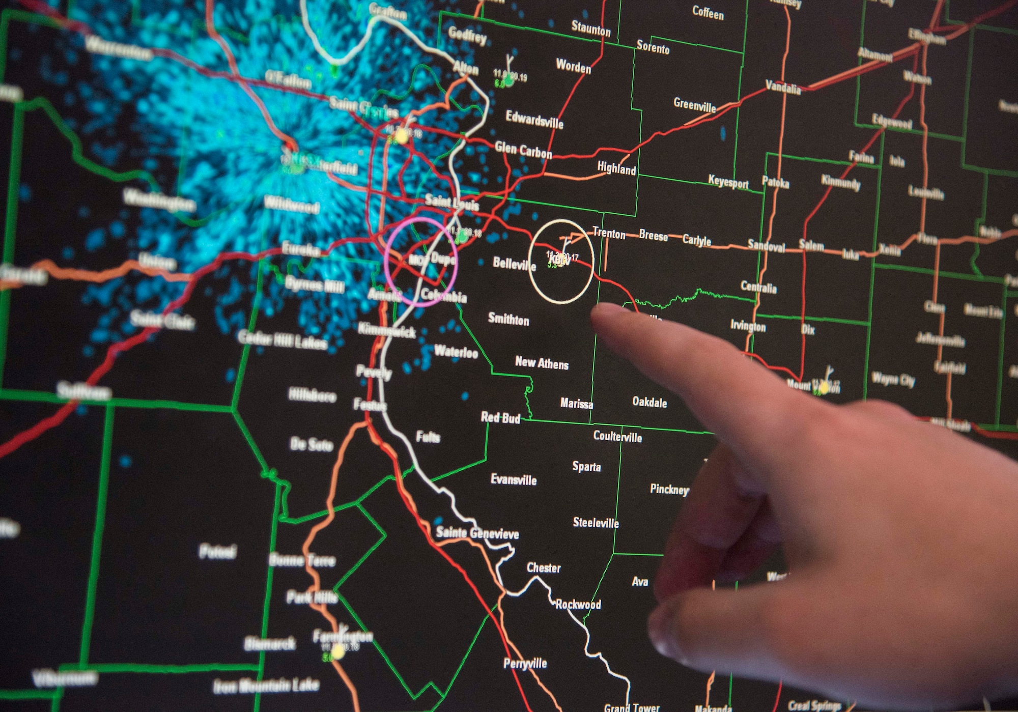 Staff Sgt. John Breon, 15th Operational Weather Squadron weather journeyman, points out the current weather affecting Scott Air Force Base and the surrounding area. The mission of the 15th OWS is delivering environmental intelligence by monitoring weather patterns and systems that might affect various military bases. (U.S. Air Force photo by Airman 1st Class Nathaniel Hudson)